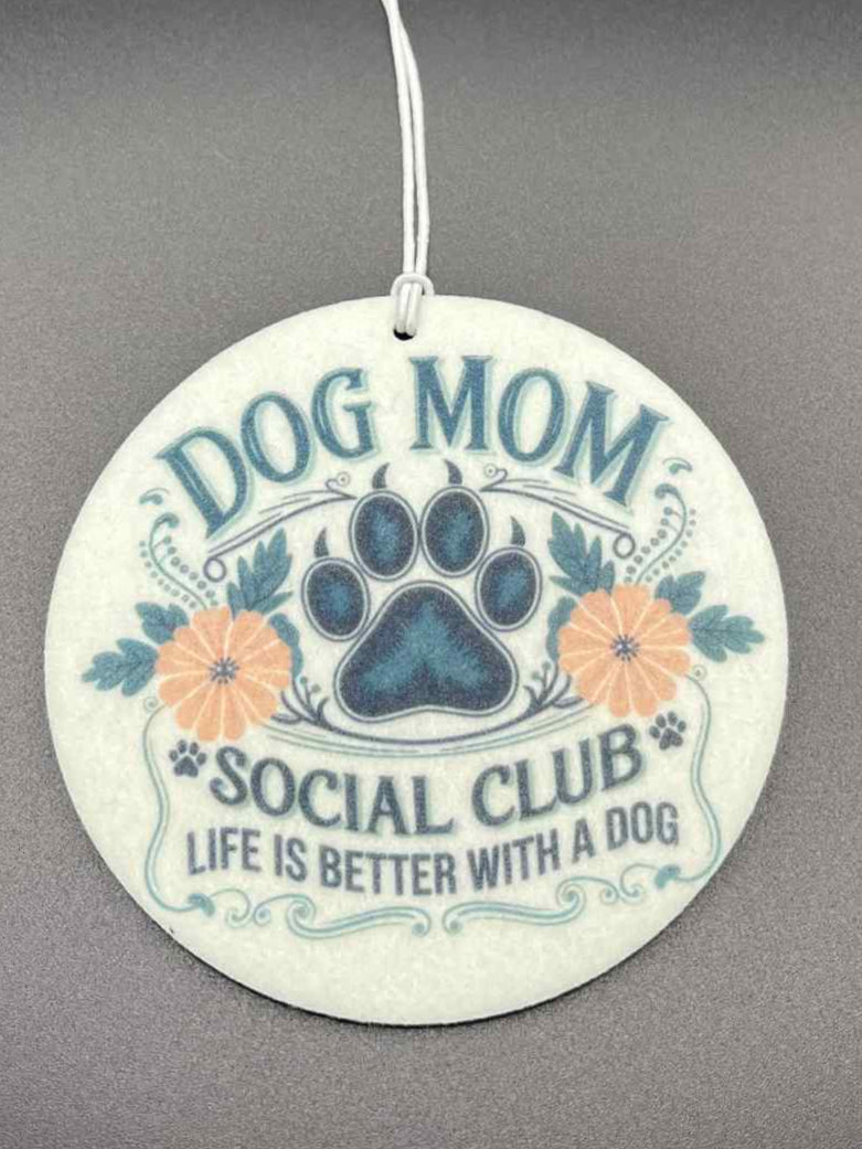 Round air freshener with 'Dog Mom Social Club' text and paw print on a dark background